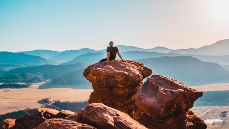 Man atop Majestic Mushroom Rock Formation wallpaper