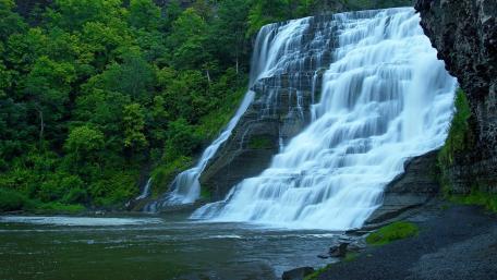 Majestic Waterfall Amidst Lush Greenery wallpaper