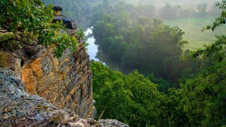 Majestic Cliff Overlooking Serene Ravine Scene wallpaper