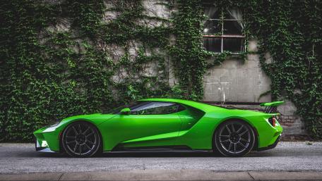 Vibrant Green Supercar Against Urban Backdrop wallpaper