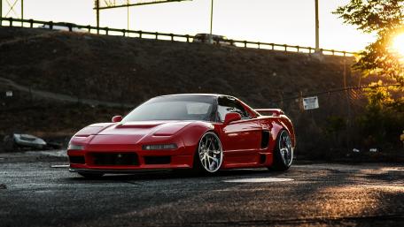 Sleek Red Sports Car in Sunset Glow wallpaper
