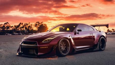 Sleek Red Performance Car Under Sunset Sky wallpaper
