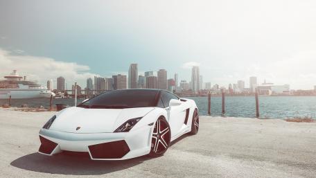 Sleek White Sports Car Against City Skyline wallpaper