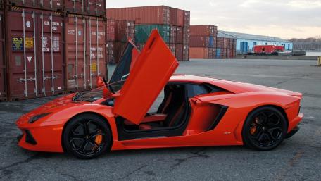 Sleek Orange Supercar with Lifting Doors wallpaper