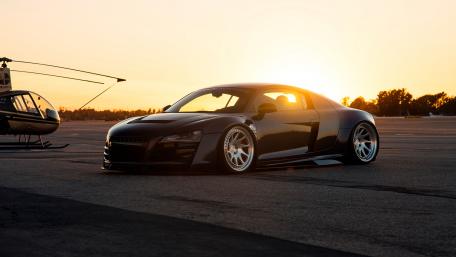 Sleek Black Car Amidst Stunning Sunset Scene wallpaper