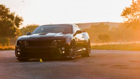 Sleek Black Camaro Under Golden Sunrise Light wallpaper