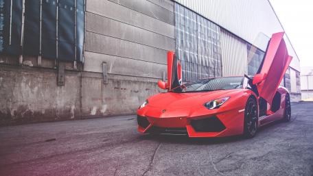 Sleek Red Lamborghini with Iconic Doors Up wallpaper