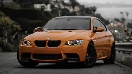 Sleek Orange BMW M3 on the Road wallpaper