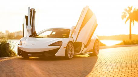 Sleek McLaren by the Sunset Shoreline wallpaper