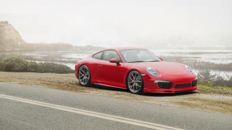 Sleek Red Porsche on a Scenic Roadside wallpaper