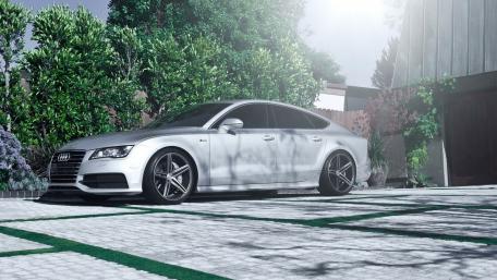 Sleek Audi A7 in a Lush Garden Setting wallpaper