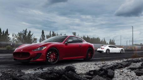 Sleek Red and White Sports Cars Under Dramatic Skies wallpaper