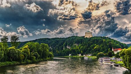 Majestic River Landscape Under Dramatic Clouds wallpaper