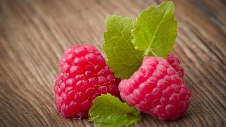 Fresh and Juicy Raspberries on Wooden Surface wallpaper