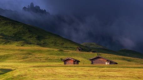 Serene Cottage in a Green Field Amidst Clouds wallpaper