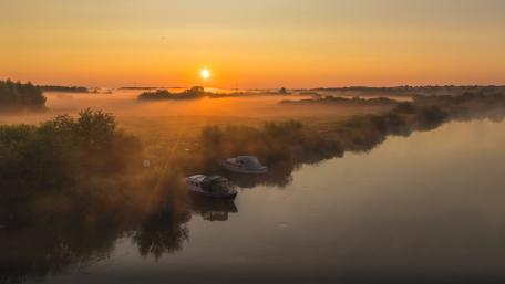 Serene Lakeside Sunset with a Boat wallpaper