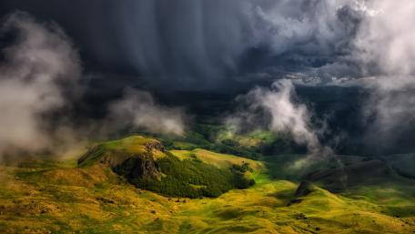 Dramatic Clouds Over Verdant Hillside wallpaper