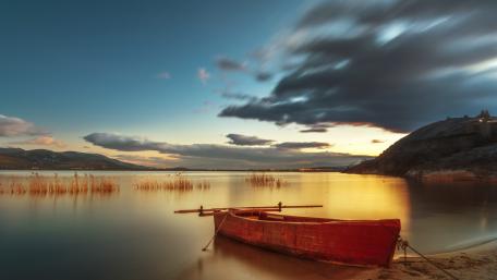 Serene Sunset by the Lake with a Boat wallpaper