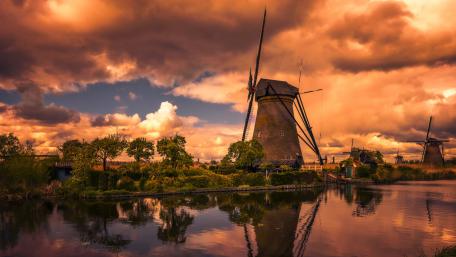 Enchanted Dutch Sunset Over Windmills Reflecting in Tranquil Waters wallpaper