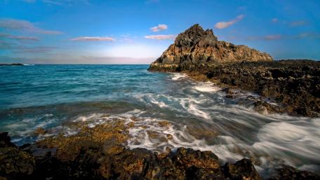 Serene Coastal Landscape with Azure Waters and Rocky Outcrop wallpaper