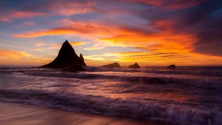 Stunning Sunset Over Serene Waves and Sea Stacks wallpaper