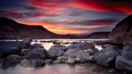 Serene Sunset Over Rocky Shoreline wallpaper