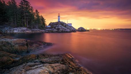 Serene Lighthouse at Dusk Overlooking the Ocean wallpaper