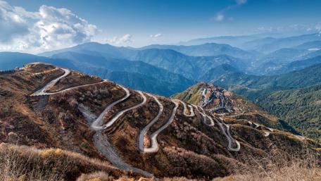 Winding Path Through Majestic Mountains wallpaper