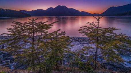 Serene Purple Sunset Over Tranquil Lake wallpaper