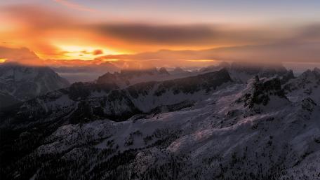 Majestic Winter Sunset Over Snowy Mountains wallpaper