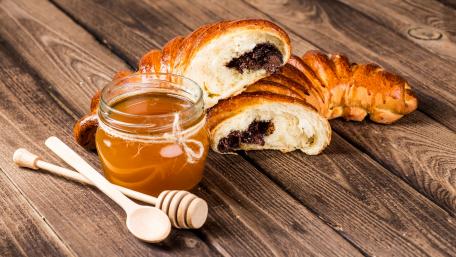 Delicious Croissants with Honey on Wooden Planks wallpaper