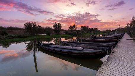Serene Sunset Reflection Over Calm Waters and Boats wallpaper