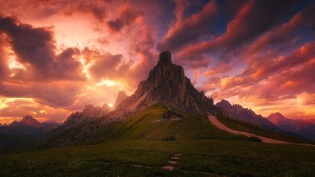 Majestic Mountain Lodge Beneath Colorful Clouds wallpaper