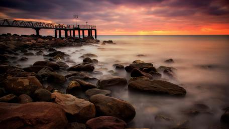 Serene Sunset Over the Pier and Shoreline wallpaper