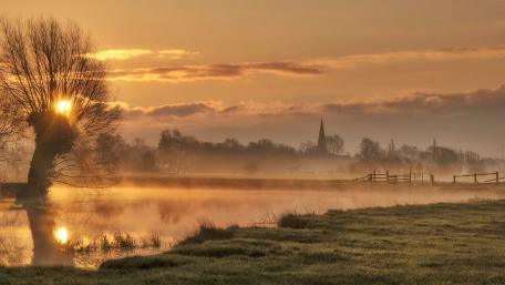 Serene Misty Sunrise Over Tranquil Landscape wallpaper
