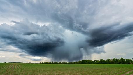Majestic Storm Clouds Over a Green Field wallpaper