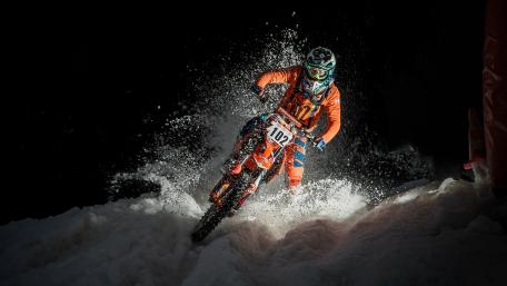 Adventurous Motorcycle Rider in Snowy Terrain wallpaper