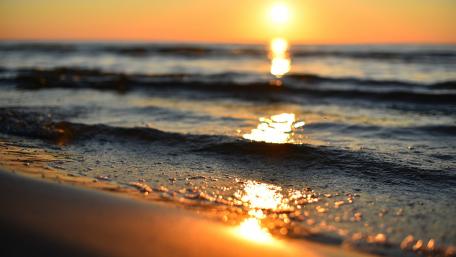 Golden Sunset Over Calm Ocean Waves wallpaper
