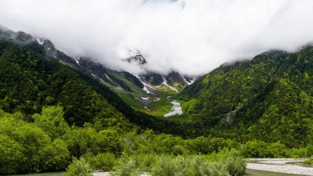 Serene Mountain Landscape Under Cloudy Skies wallpaper