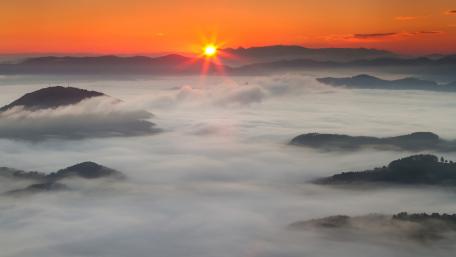 Serene Sunrise Over Misty Mountains wallpaper