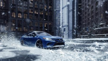 Blue Toyota Camry Splashing Through City Snowfall wallpaper