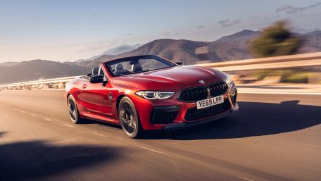 Sleek BMW Cabriolet Driving Through Scenic Landscape wallpaper