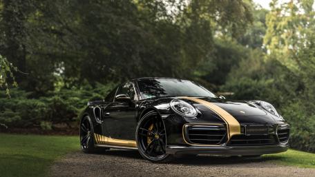 Sleek Black Porsche with Gold Accents Wallpaper wallpaper