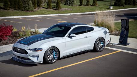 Sleek Mustang Charging at a Modern Station wallpaper