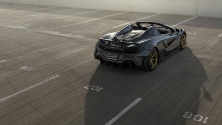 Sleek McLaren Sports Car on a Quiet Lot wallpaper
