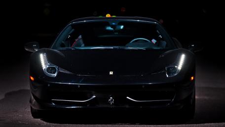 Sleek Black Sports Car Under Dramatic Lighting wallpaper