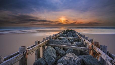 Serene Sunset Over Tranquil Beach Waters wallpaper