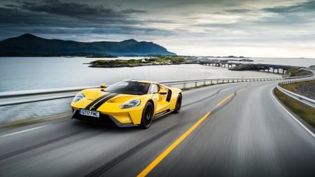 Sleek Yellow Supercar on Coastal Road wallpaper