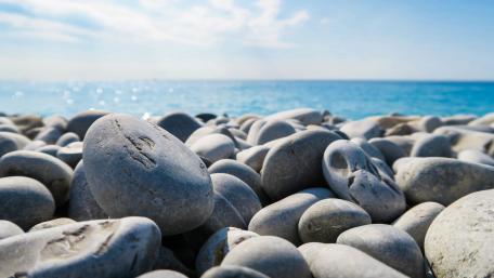 Tranquil Beach Stones Under Blue Sky wallpaper