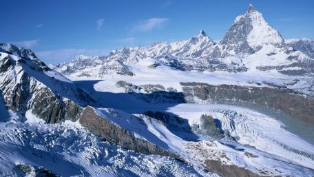 Majestic Snow-Capped Mountains Under Clear Blue Sky wallpaper